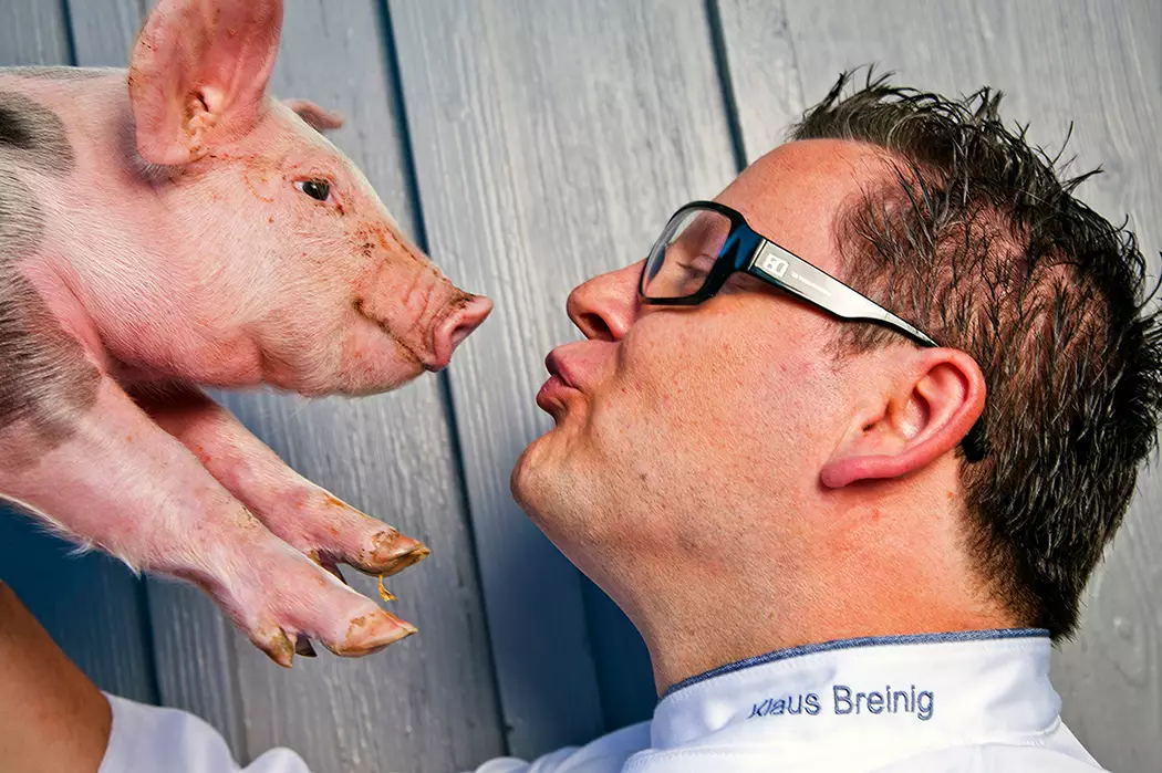 Koch Klaus Breinig wirft einem Ferkel einen Kussmund zu - humorvolles Portrait - Vorschau Portraitgalerie.