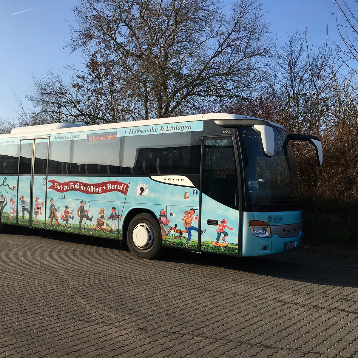 Busbeklebung – »Gut zu Fuß in Alltag + Beruf!« mit Figurenillustrationen.