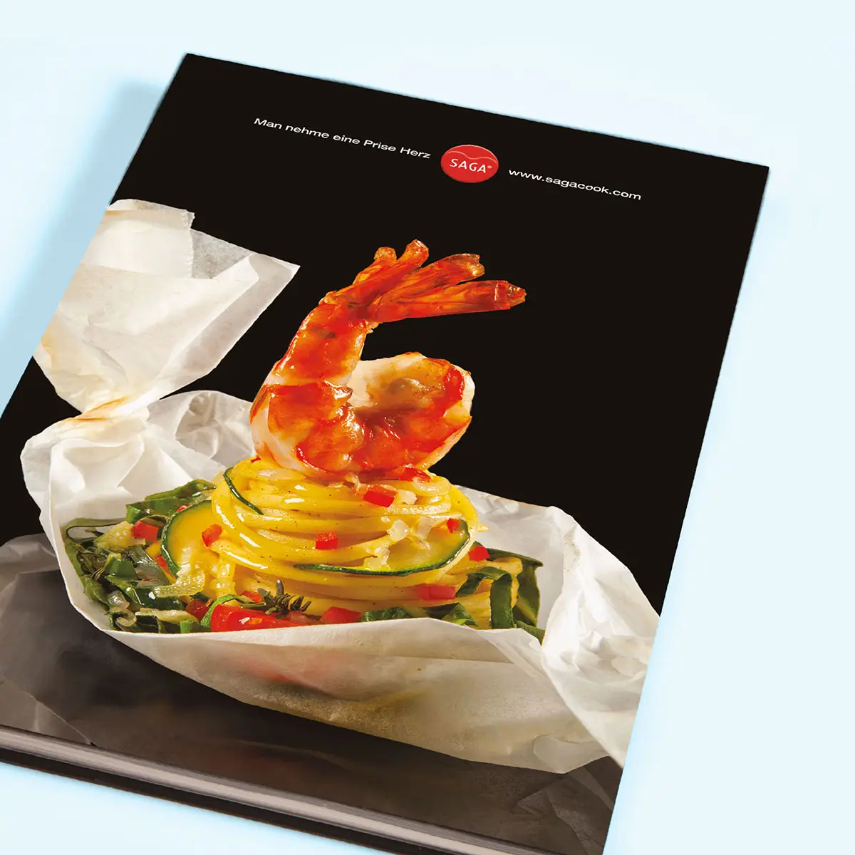 SAGA Cook – Kochbuch/Verpackung: Garnele im Backpapier, Claim »Man nehme eine Prise Herz«
