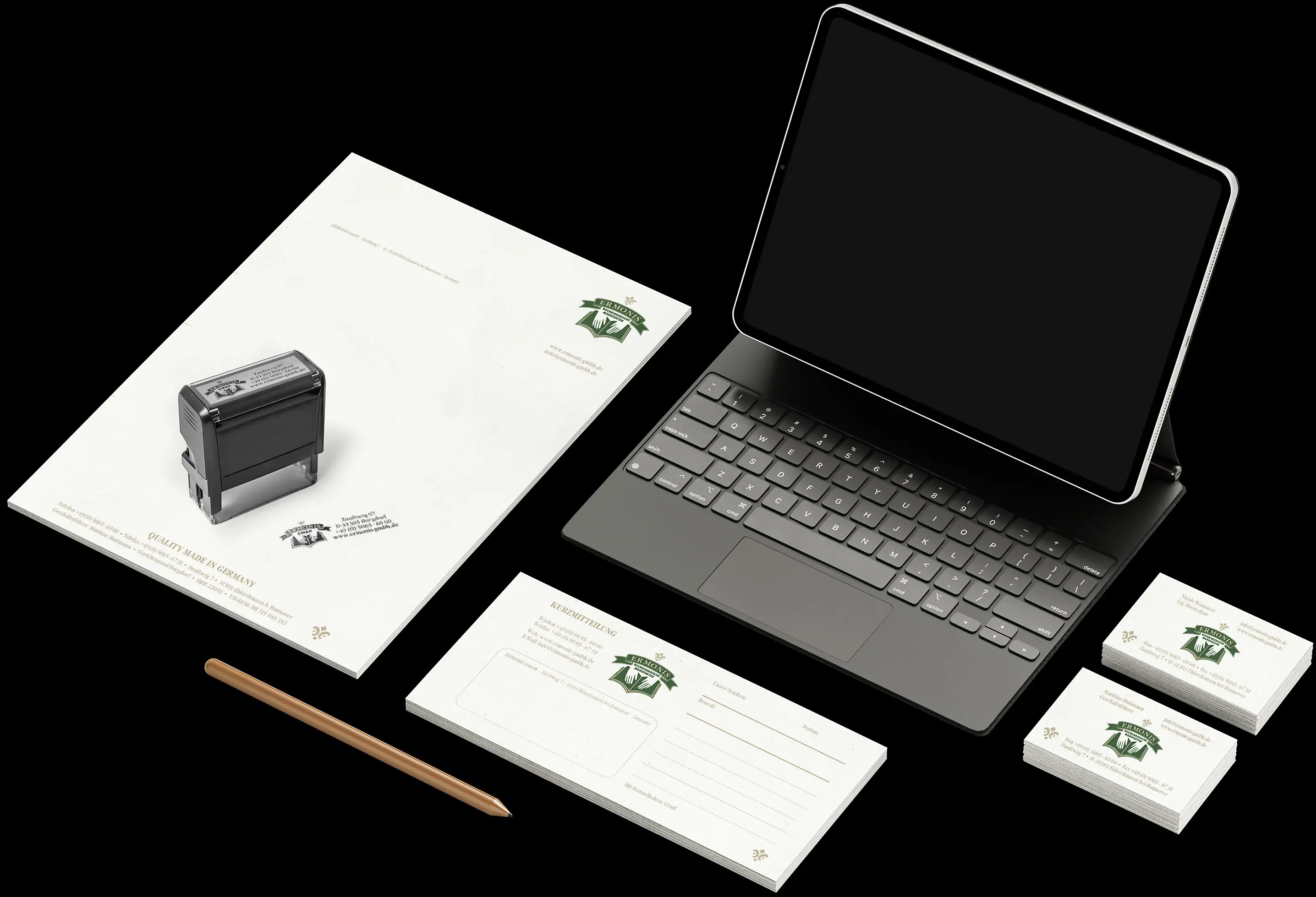 ERMONIS Corporate Design: Briefpapier, Stempel, Karten und Laptop.